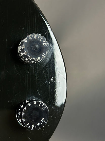 Close-up of a vintage typewriter's control panel with two circular dials on a blurred background.