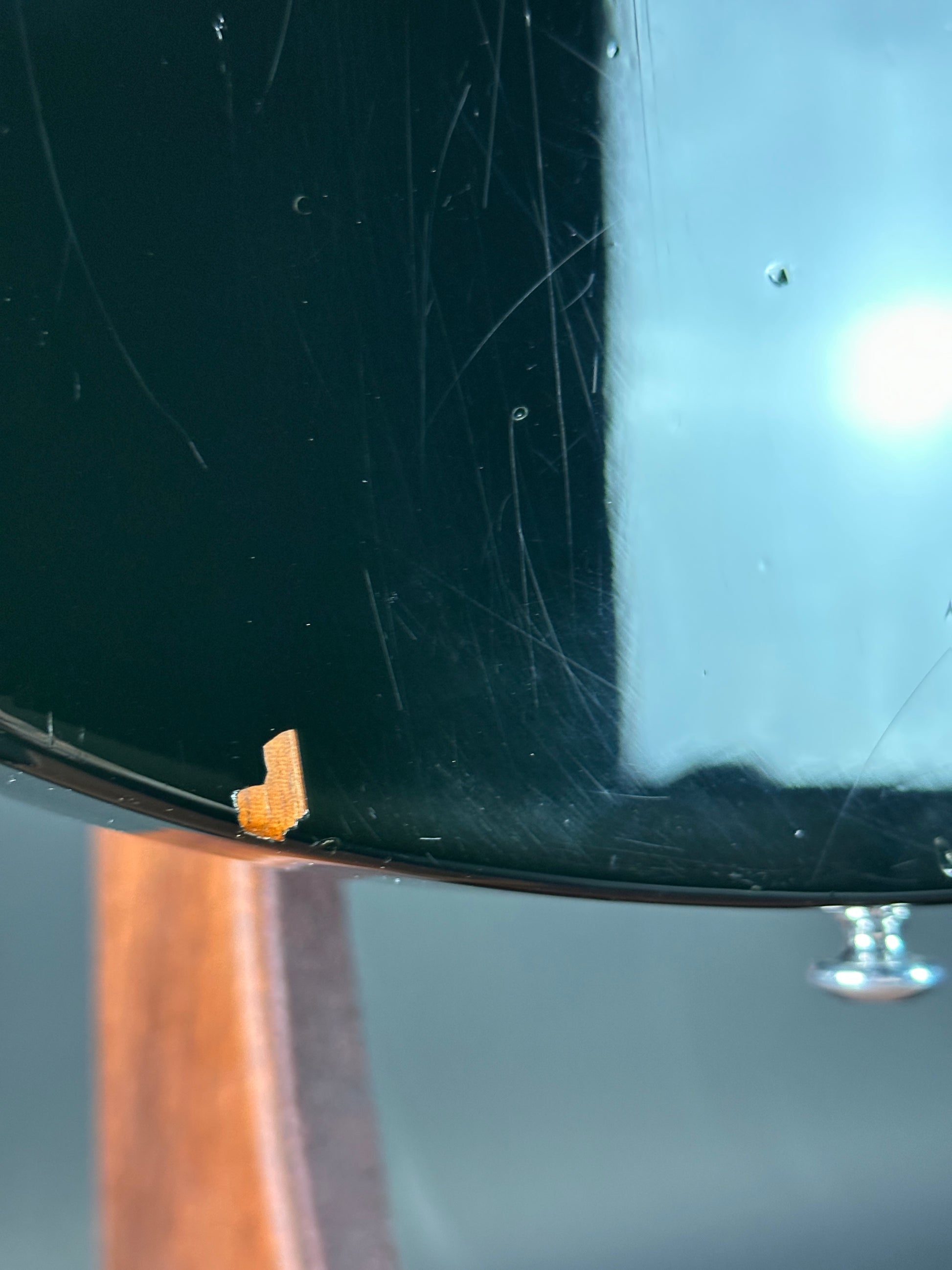 Close-up of a guitar with a small piece of wood attached to the body