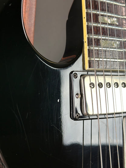 Close-up of a black electric guitar with visible strings and body