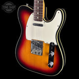 A classic Fender Telecaster electric guitar with a sunburst finish, featuring a white pickguard, black control plate, and chrome hardware, shown against a solid black background.