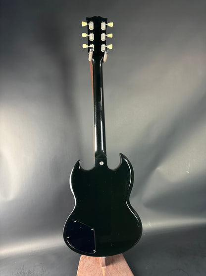 Black electric guitar on a gray background