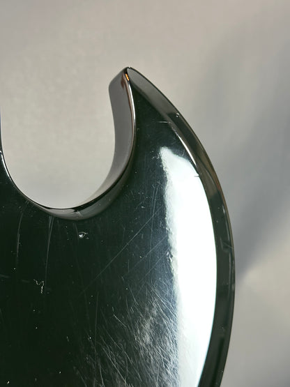 Close-up of a metallic object with a reflective surface on a gray background