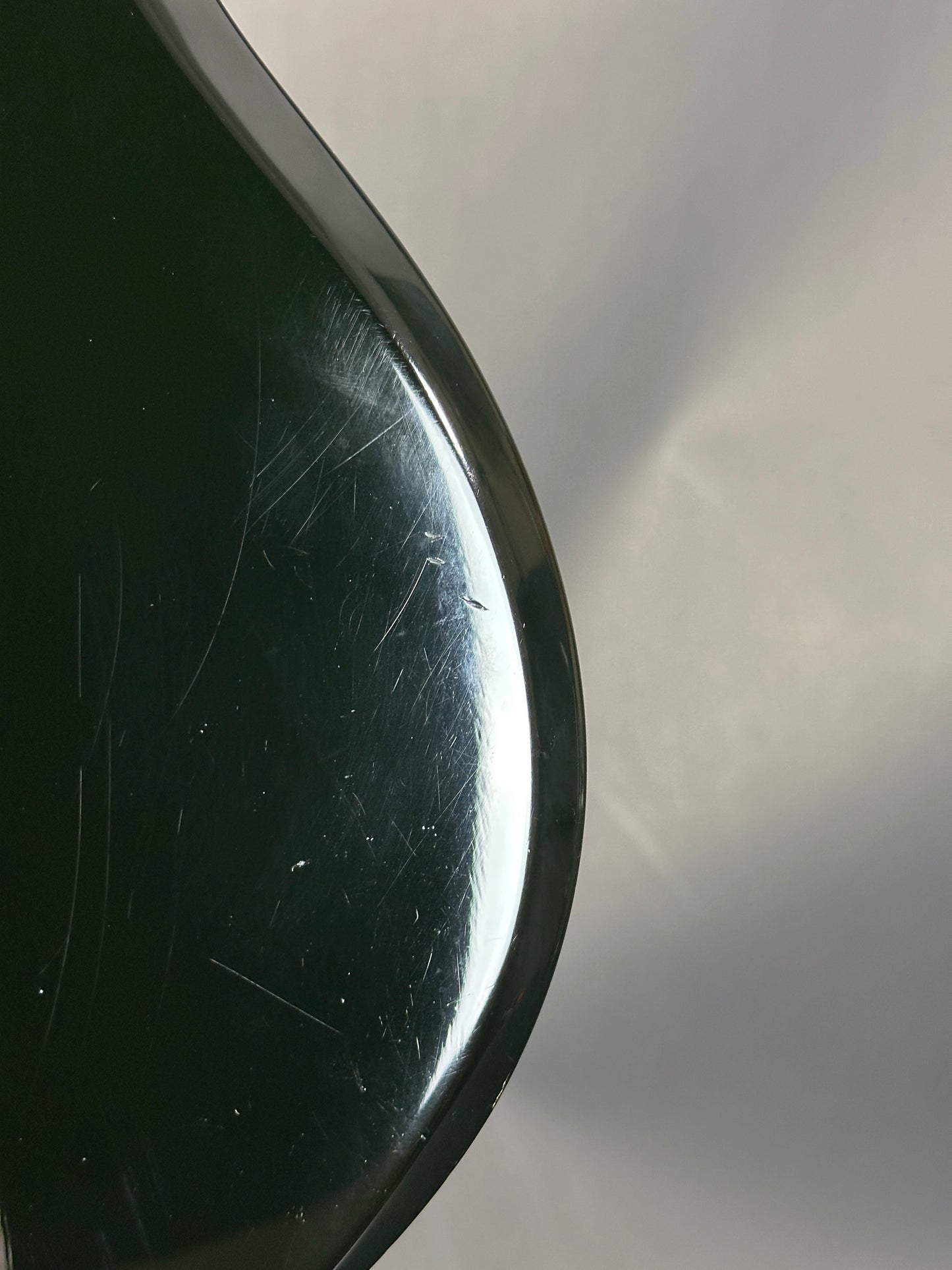Close-up of a metallic object with reflective surface and visible scratches.