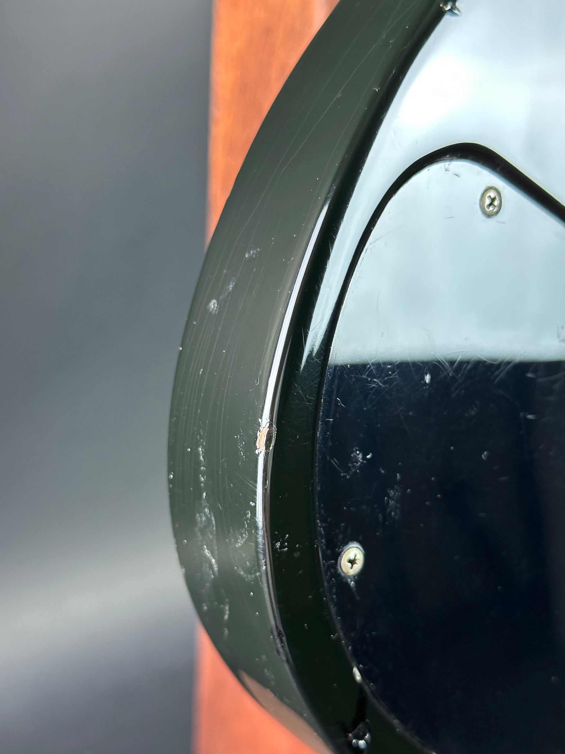 Close-up of a round metallic object with a reflective surface on a dark background