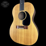 A vintage acoustic guitar with a natural wood finish and black pickguard, shown against a solid black background with a Tone Shop watermark in the top left corner.