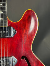 Close-up of a red electric guitar with a dark background