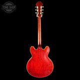 Red electric guitar on a black background with 'Tone Shop' logo.