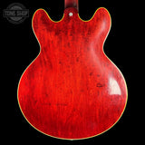 Red electric guitar body on a black background with 'Tone Shop' logo.