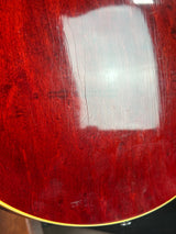 Close-up of a red guitar with visible wear and tear