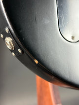 Close-up of a black metal object with a brown handle on a gray background