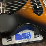 Guitar on a digital scale displaying weight
