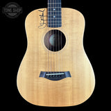 Acoustic guitar with a visible brand logo on a black background