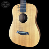 Acoustic guitar with a visible brand logo on a black background