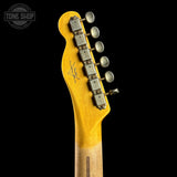 Close-up of the headstock of a guitar with a bright yellow finish and silver tuning pegs, shown against a black background. A Tone Shop watermark is visible in the top left corner.