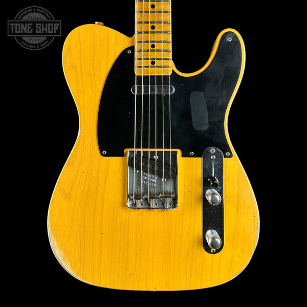 A classic Fender Telecaster electric guitar in a natural yellow finish, featuring a black pickguard and chrome hardware, shown against a solid black background with a Tone Shop watermark in the top left corner.