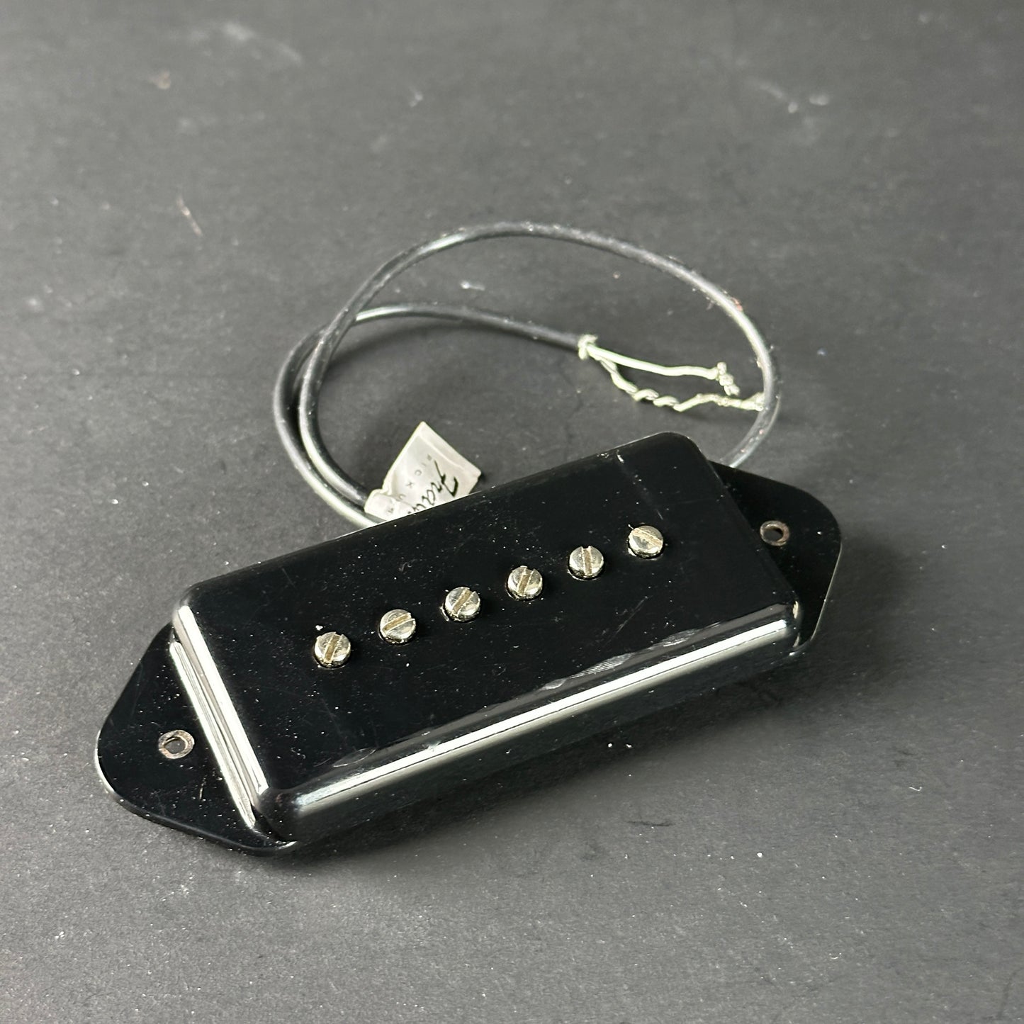 Black guitar pickup on a gray surface