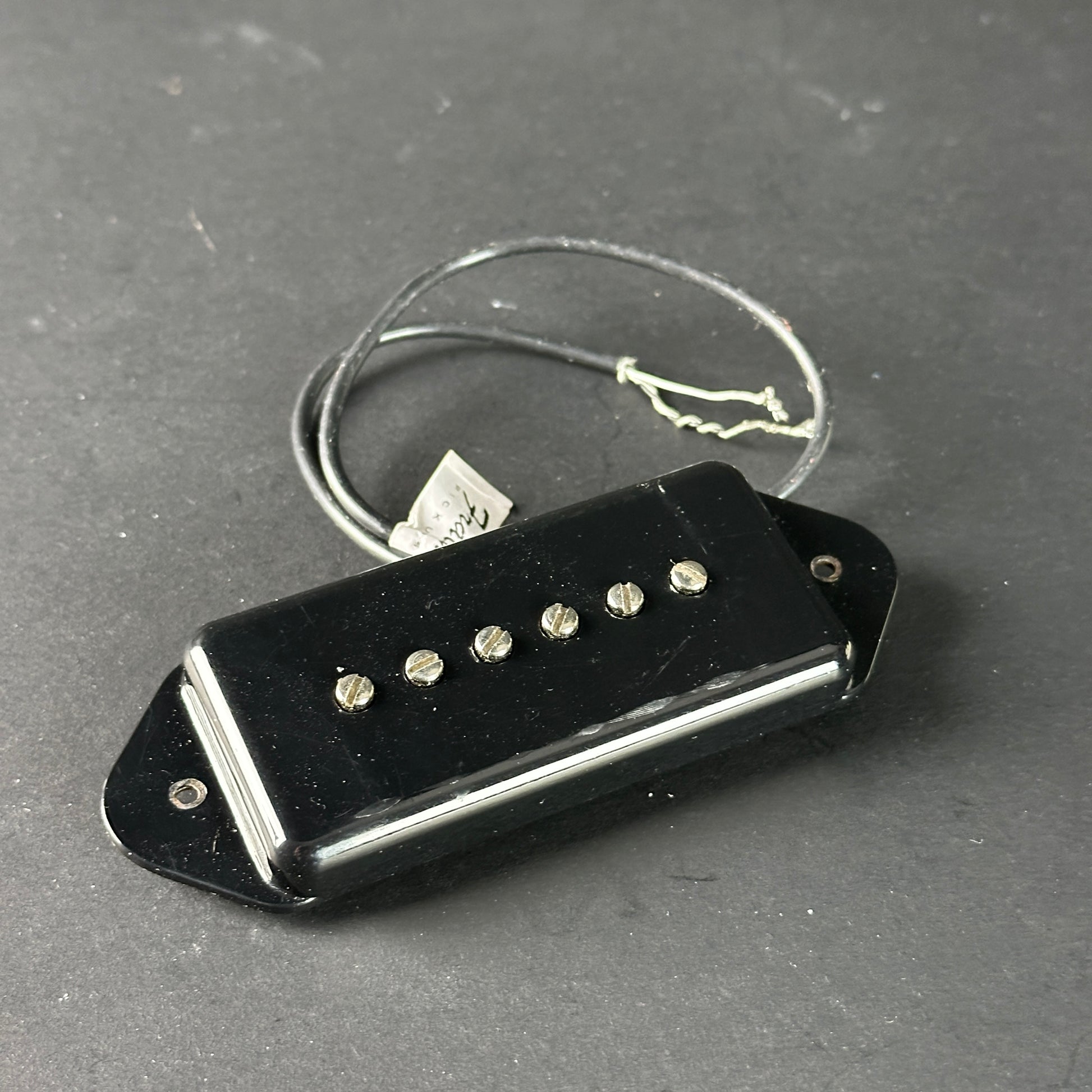 Black guitar pickup on a gray surface
