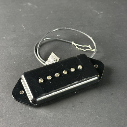 Black guitar pickup on a gray surface