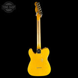 A yellow-finish electric guitar shown from the back against a solid black background, with a Tone Shop watermark in the upper left corner.
