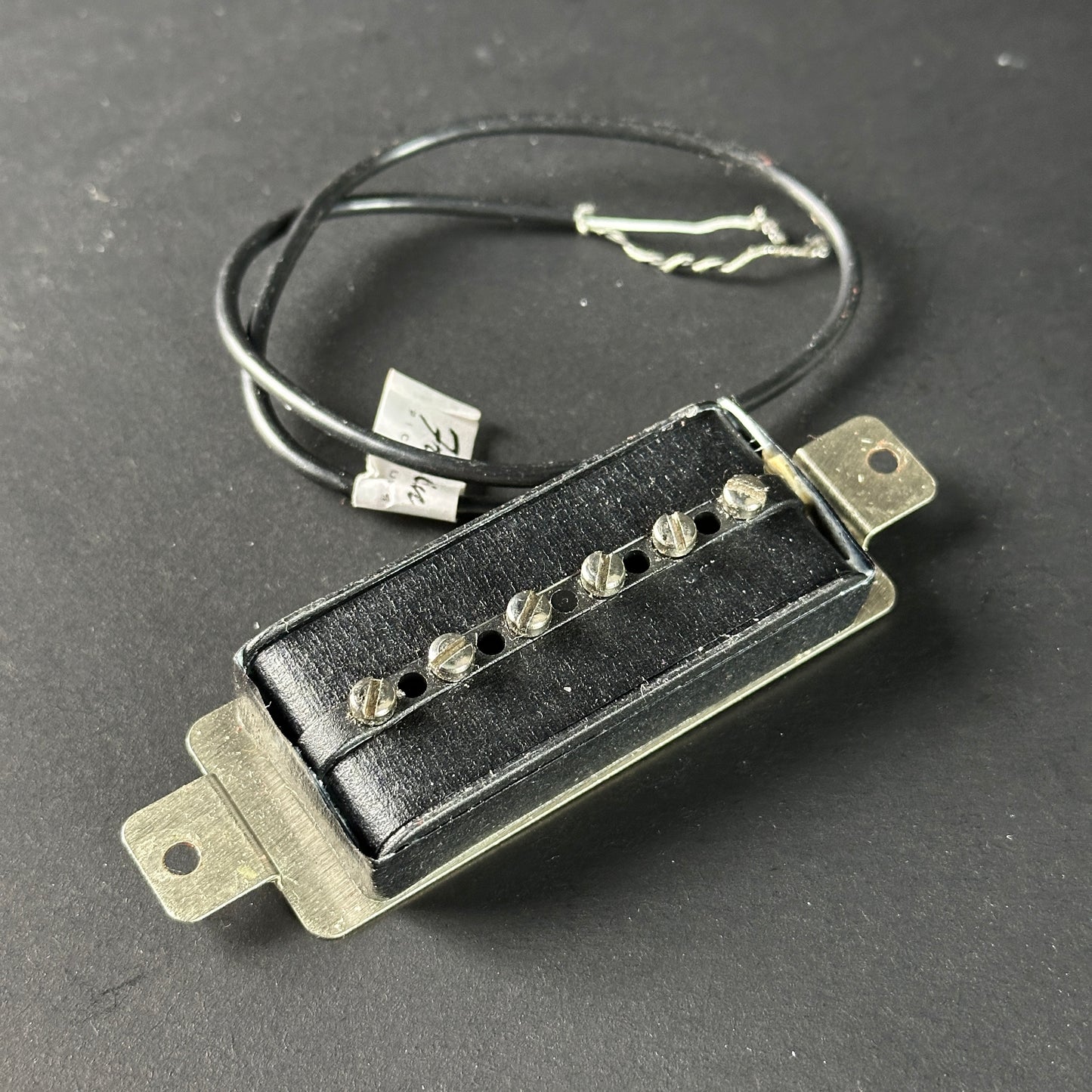 Guitar pickup with wiring on a dark background