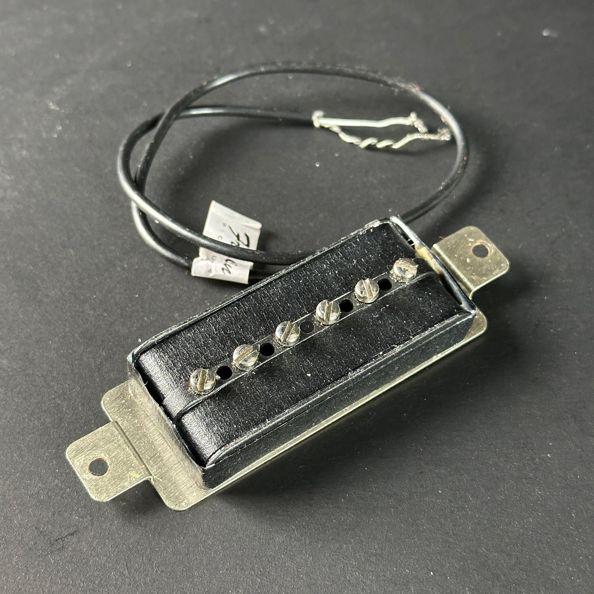 Guitar pickup with wiring on a dark background