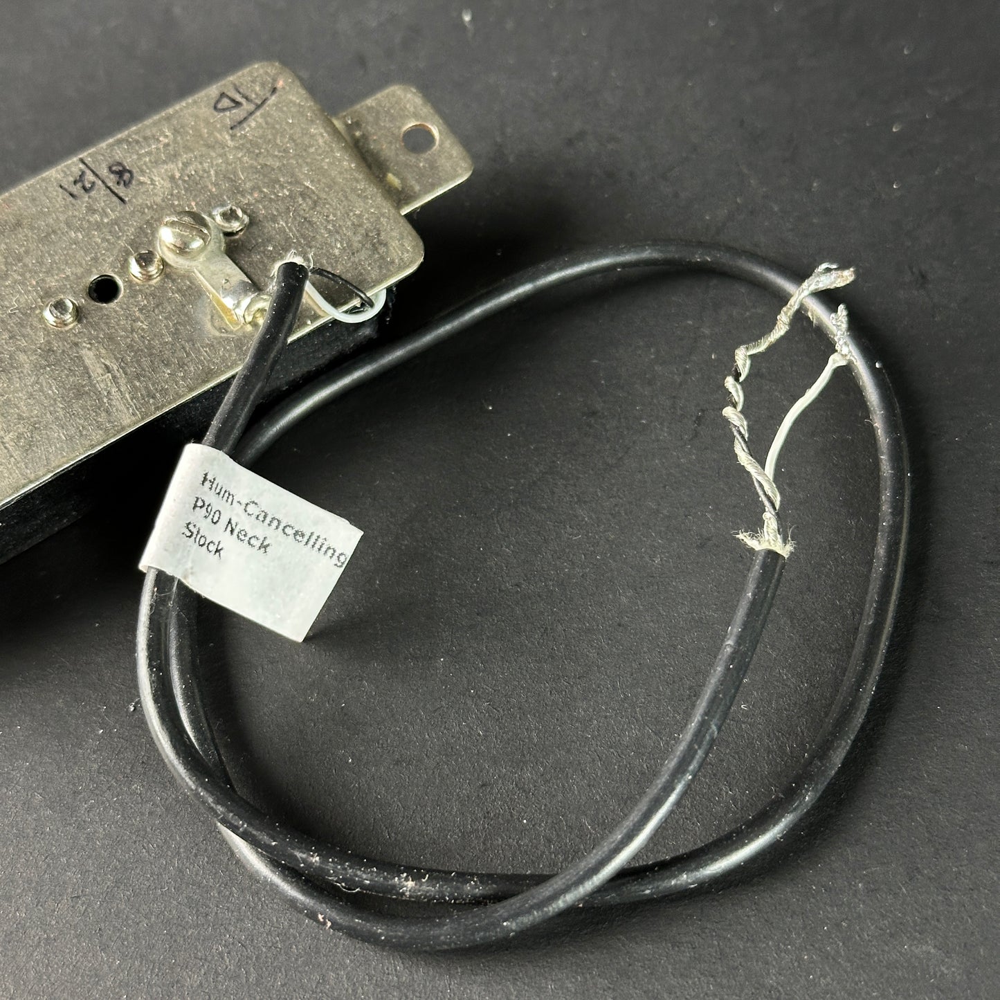 Humbucker pickup with a cable on a dark background