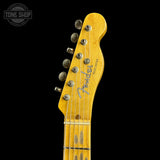 Close-up of a Fender Telecaster electric guitar headstock in a natural maple finish, showing six silver tuning pegs and the Fender logo, set against a solid black background.