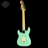 Turquoise electric guitar with a black background