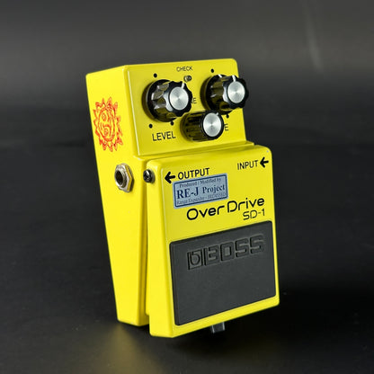 Yellow guitar effects pedal with 'Boss' branding on a dark background