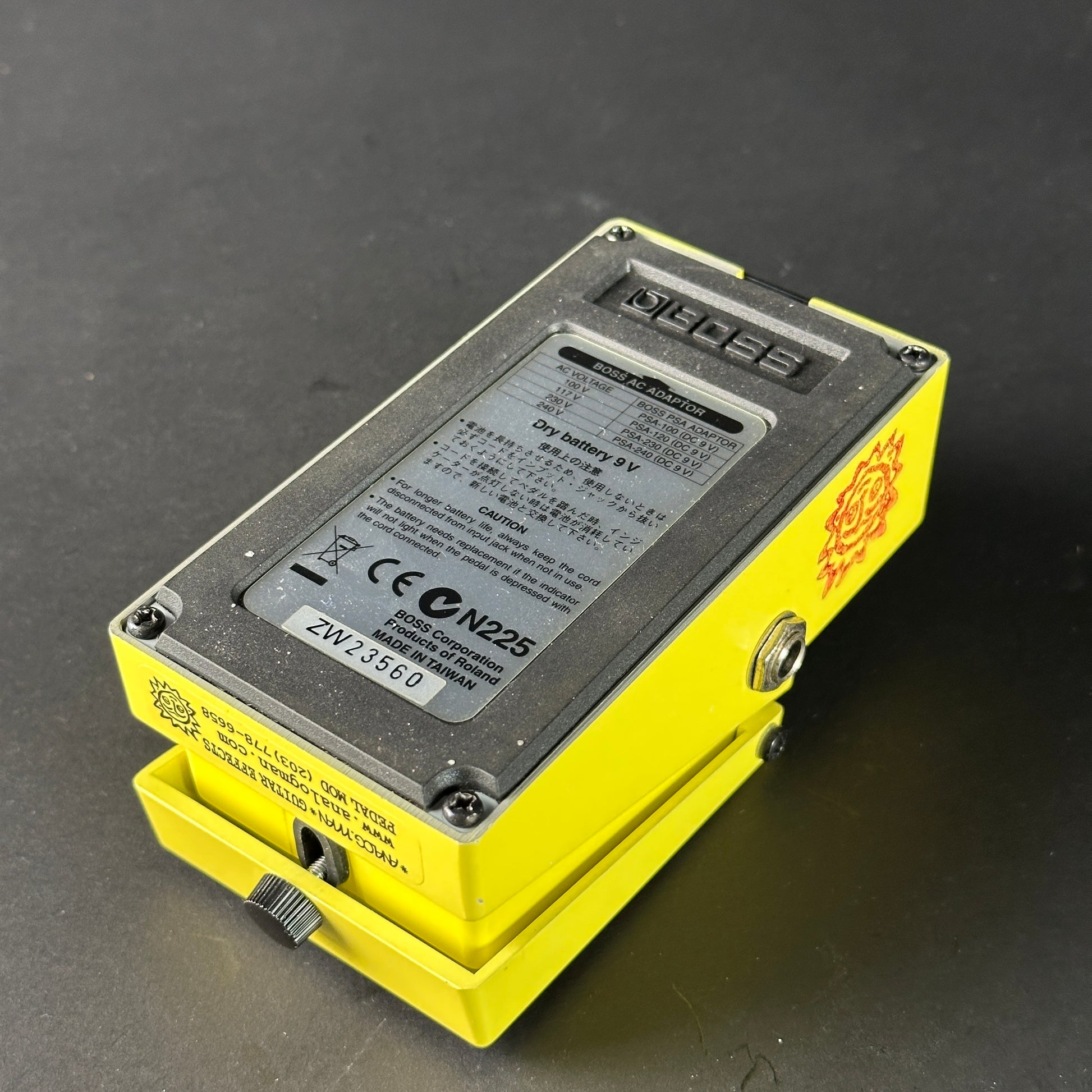 Yellow electronic device with a battery label on a dark background