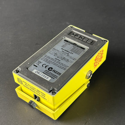 Yellow electronic device with a battery label on a dark background