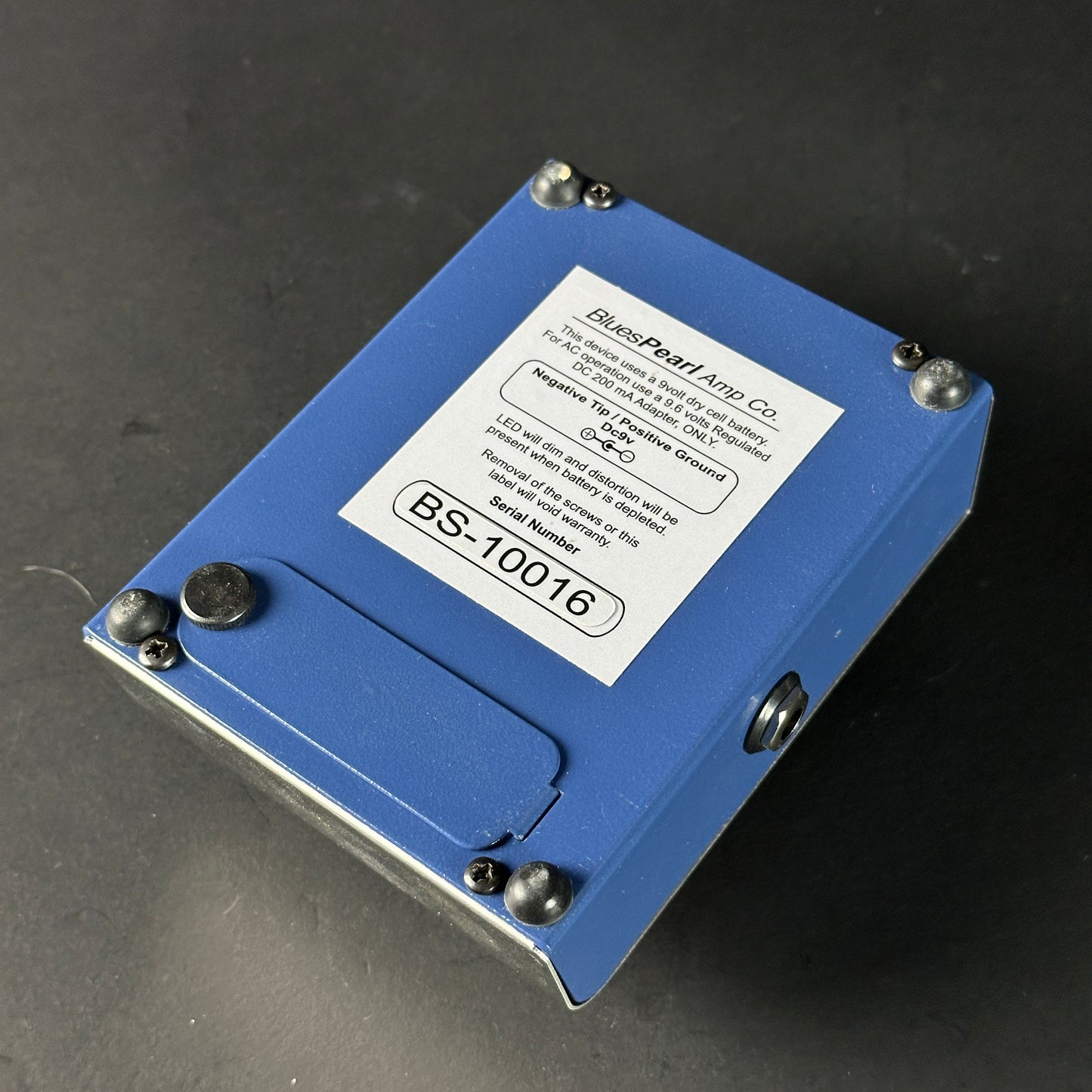 Blue electronic component with a label on a dark background