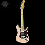 Electric guitar with a pink body and blonde fretboard on a black background