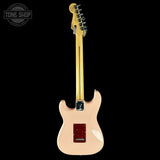 Electric guitar with a beige finish on a black background, featuring the Tone Shop logo.