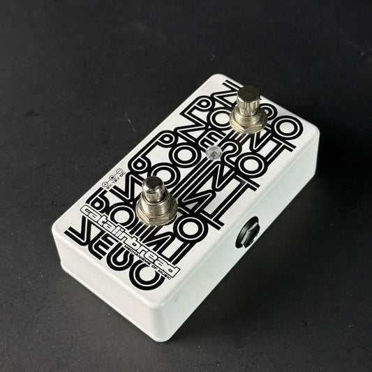 White guitar effects pedal with black text on a dark background