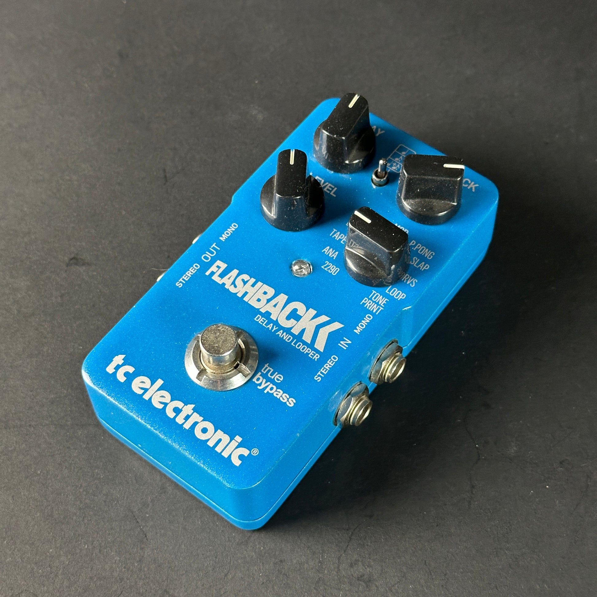 Blue tc electronic Flashback guitar effects pedal on a dark gray background