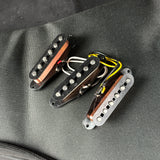 Three guitar pickups on a gray fabric background