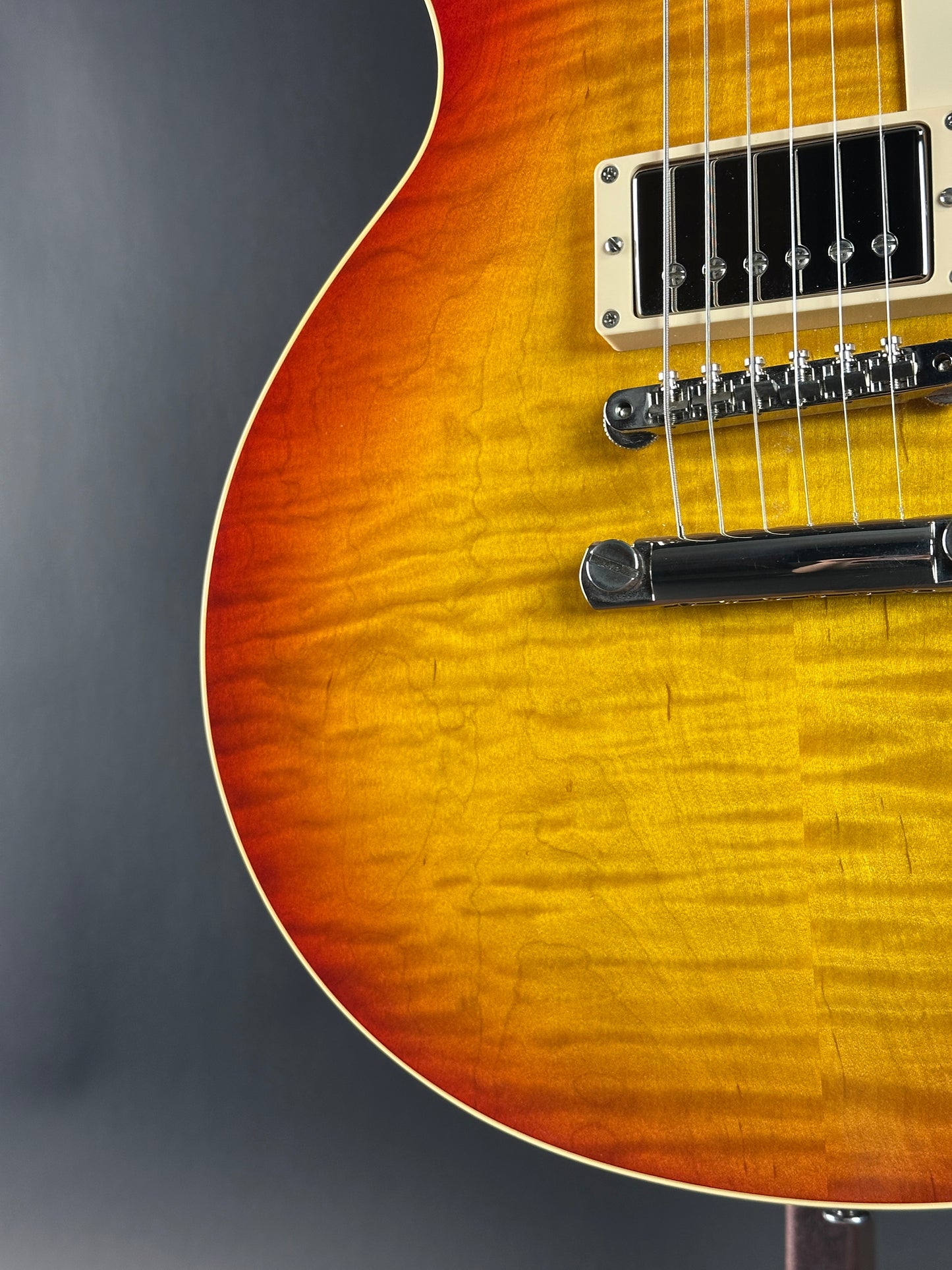Close-up of a sunburst electric guitar on a gray background
