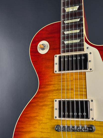Close-up of a Les Paul electric guitar with a sunburst finish on a dark background