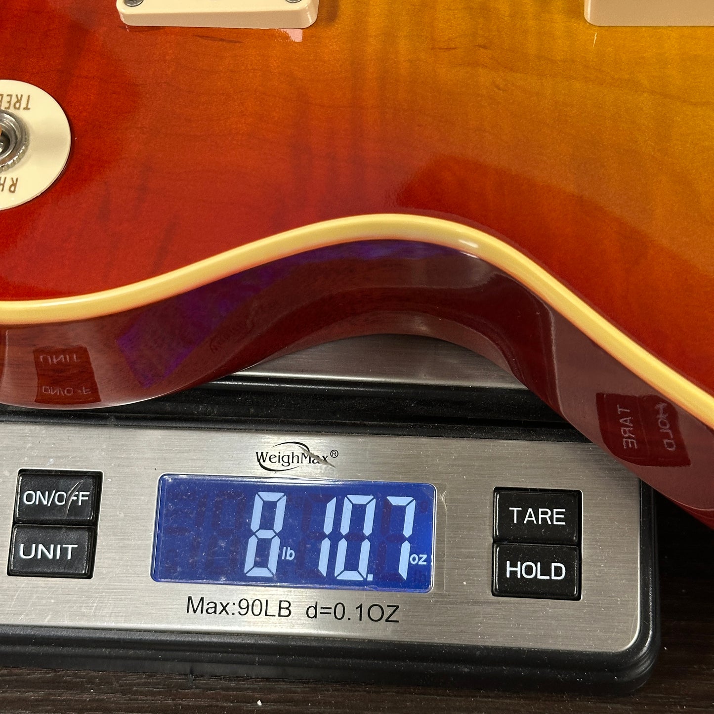 Guitar on a digital scale displaying weight