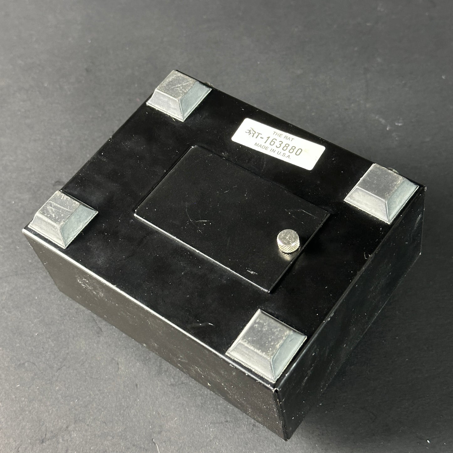 Black electronic component with metallic legs on a dark background