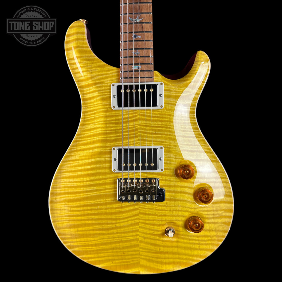 A yellow flamed maple electric guitar with a dark brown neck, chrome hardware, and three control knobs, shown against a solid black background with a Tone Shop watermark in the top left corner.