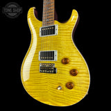 A yellow flamed maple electric guitar with a black body, chrome hardware, and a dark wood fretboard, shown against a black background with a Tone Shop watermark in the top left corner.