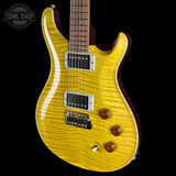 An electric guitar with a bright yellow flamed maple top, dark burgundy sides, and chrome hardware, shown against a solid black background with a Tone Shop watermark in the top left corner.
