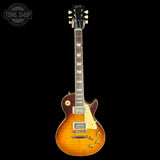 A classic electric guitar with a sunburst finish, shown against a solid black background. The brand 'Tone Shop' is visible as an overlay in the top-left corner.