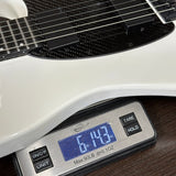 Digital scale displaying weight of a guitar on a wooden surface