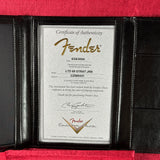 A Fender Certificate of Authenticity document displayed inside a black leather folio with red velvet lining.