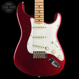 A red glitter electric guitar with a white pickguard and maple neck, shown against a black background with a Tone Shop watermark in the top left corner.