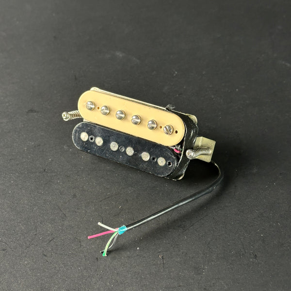 Guitar pickup with visible wiring on a dark background