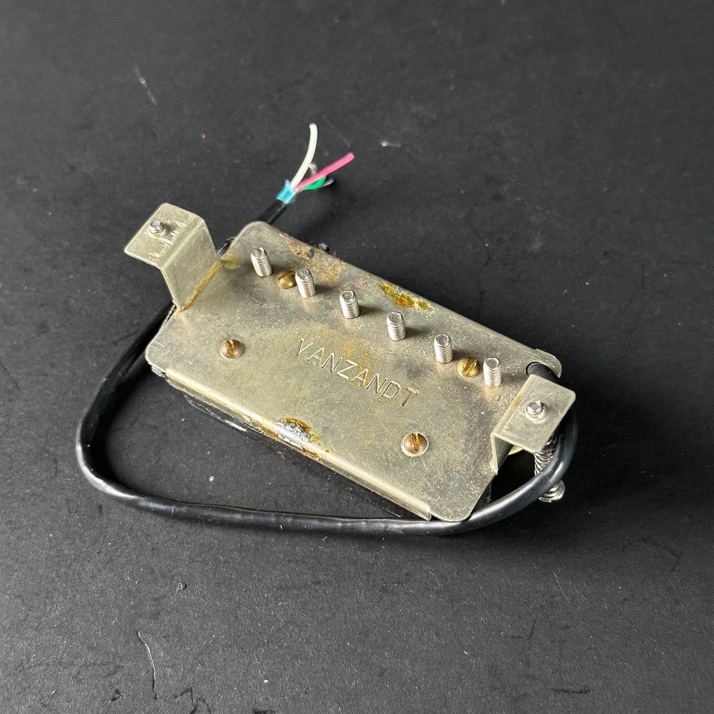 Metal component with 'Vanzandt' branding on a dark background